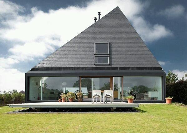 Дом со стеклянной стеной и неправильной формой крыши.