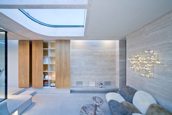 Архитектурная студия De Bever выполнила дизайн современного одноэтажного дома из стекла, бетона и травертина в Эйндховене, Нидерланды. Проект имеет множество округлых стен и окон и выходит на просторный внутренний двор с бассейном.