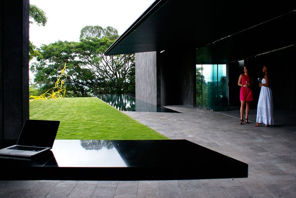 Архитектурная студия Joan Puigcorbé выполнила дизайн роскошного частного дома в Сьюдад- Колон, Коста-Рика. Дизайн проекта выполнен в серо-чёрной гамме. Темно серые поверхности каменного фасада продолжаются в интерьере. Потрясающий микс текстур — чёрные потолки, глянцевые поверхности, стекло, интегрированные линии света придают этому дому строгий ультрасовременный вид.