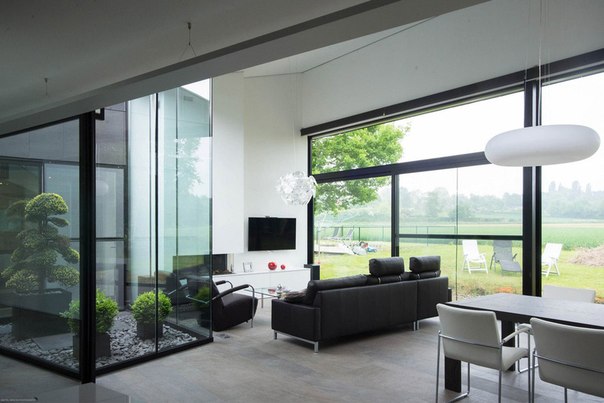 Архитектурная студия Blanco Architecten выполнила дизайн одноэтажного частного дома в Ауд-Хеверле, Бельгия. Минималистский дизайн фасада из серых каменных плиток продолжается в интерьере в нейтральных тонах с акцентами красного цвета.