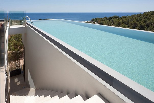 Архитектурная студия Bruno Erpicum выполнила дизайн современного частного дома с огромным бассейном на Балеарских островах Испании.